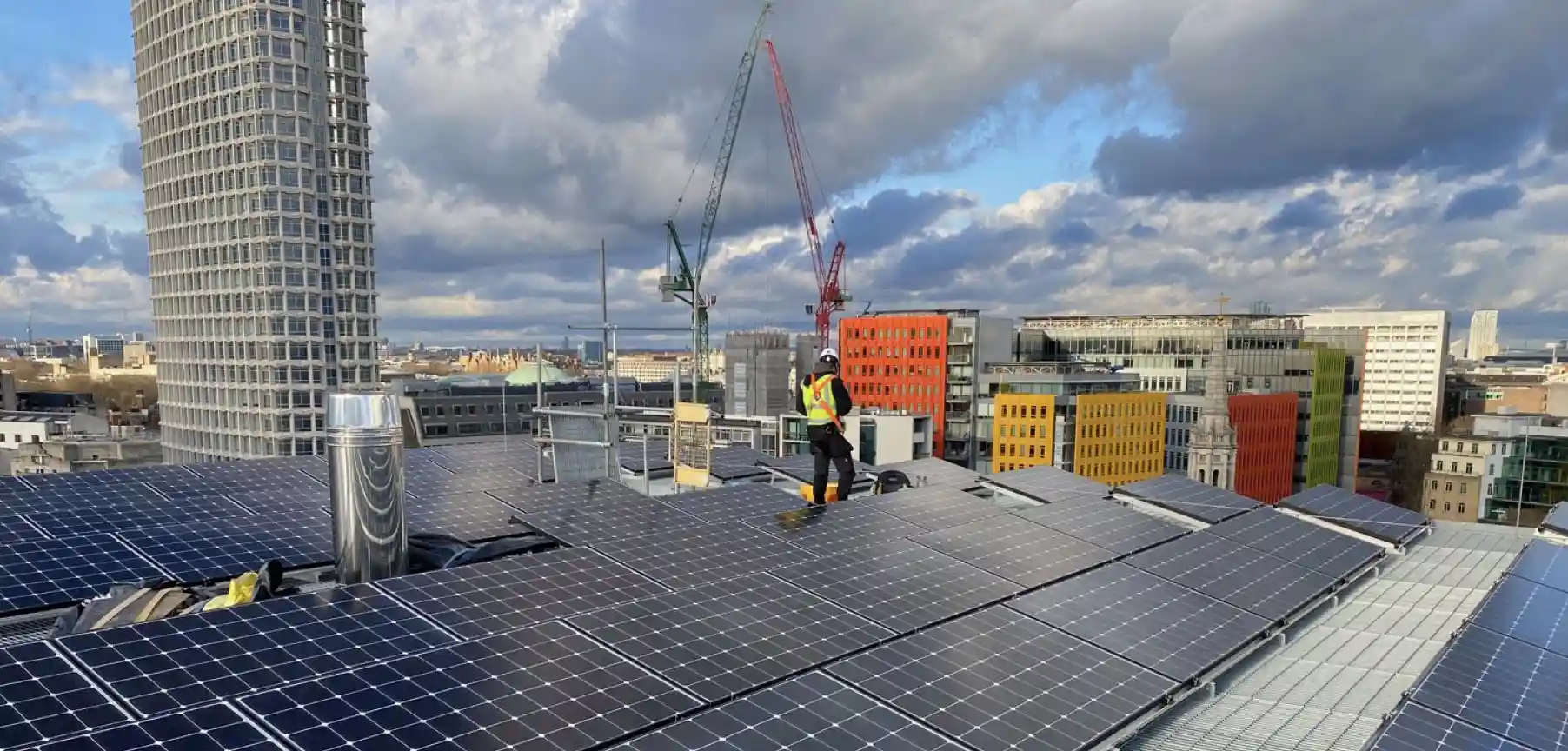 Construction worker installing solar panels on a roof