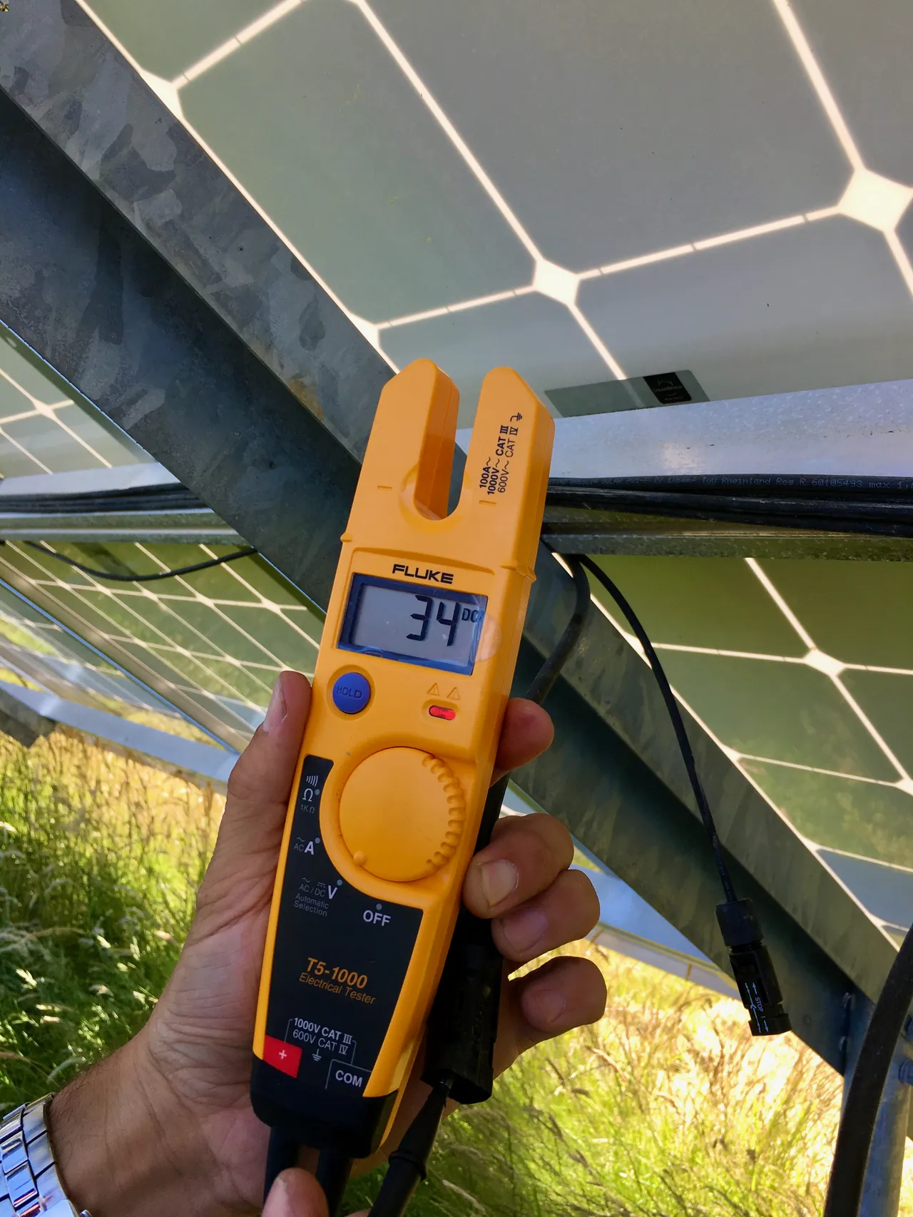 verifying the DC output voltage of a solar panel using a handheld electrical tester